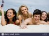 photo-of-pretty-girls-and-happy-guy-lying-on-sandy-beach-at-leisure-BWCHWB.jpg